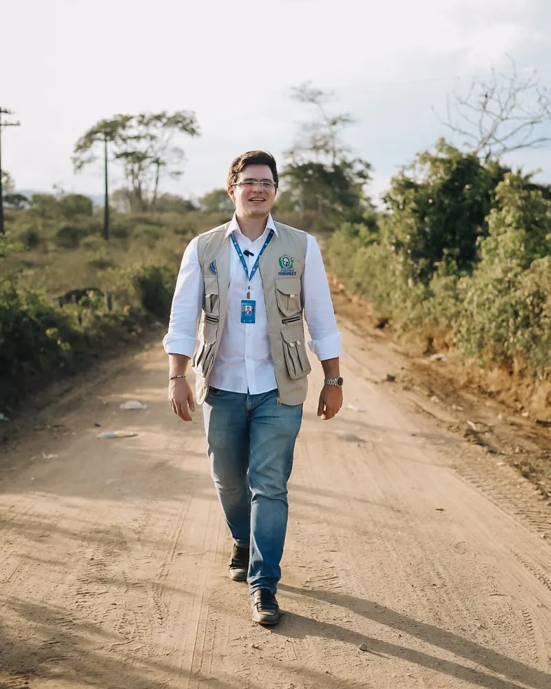 Miguel Duque caminhando numa estrada de terra no interior de Pernambuco